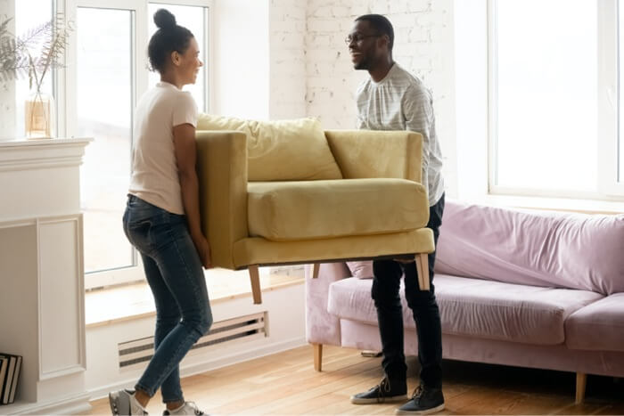 Couple moving a sofa